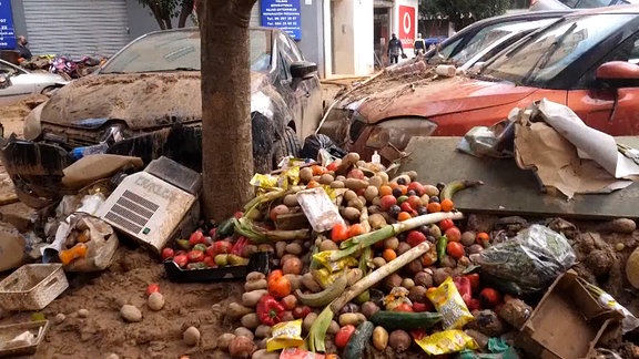 Kaputte Autos und Lebensmittel auf einer Straße 