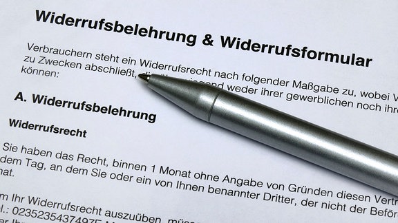 Auf einem Widerrufsformular und einer Widerrufsbelehrung liegt ein Kugelschreiber. 