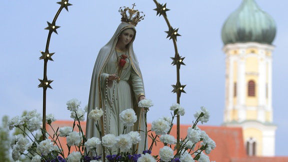 Gläubige tragen bei der Wallfahrtskirche Maria Vesperbild bei der Lichterprozession eine Marienstatue