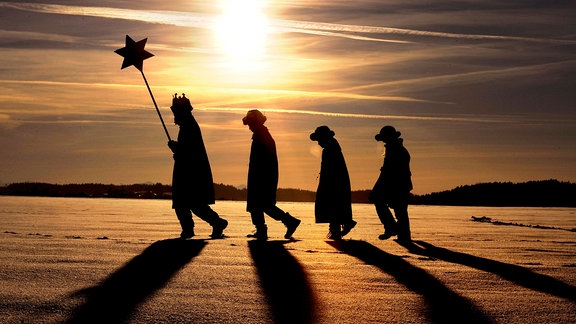 Sternsinger laufen durch die Schneebedeckten Felder.