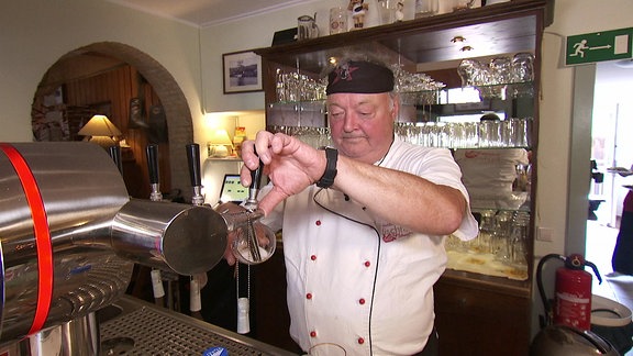 Ein Mann zapft ein Bier