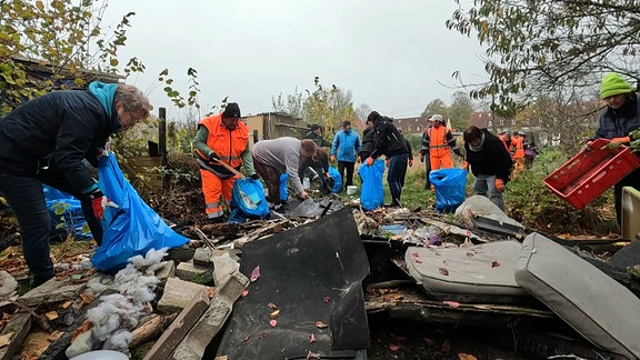 Gartenfreunde beräumen die Überreste von Brandstiftungen in ihrer Sparte