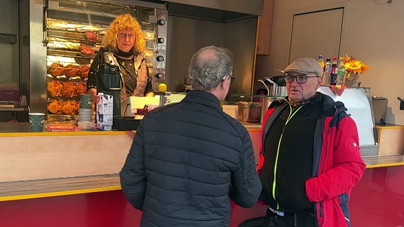 Marktleiter des Wochenmarktes in Arendsee im Gespräch mit einem Händlerkollegen