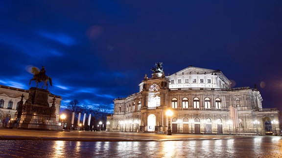 Nächtliche Aufnahme der Semperoper auf dem Theaterplatz neben dem Reiterstandbild von König Johann.