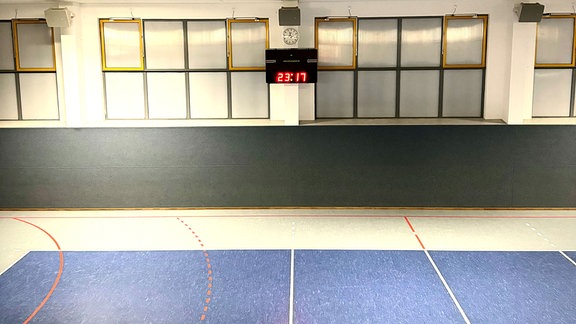 Blick in eine Sporthalle mit Spielstandsanzeige