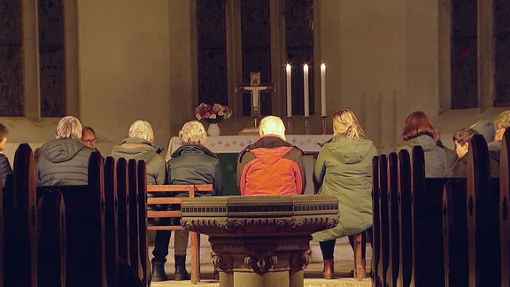 Menschen sitzen in einer Kirche