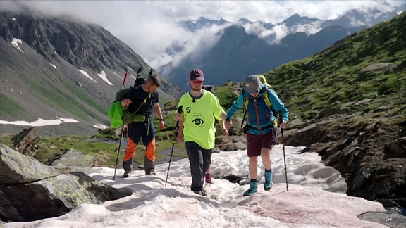 Drei wanderer auf einem Schneefeld im Hochgebirge