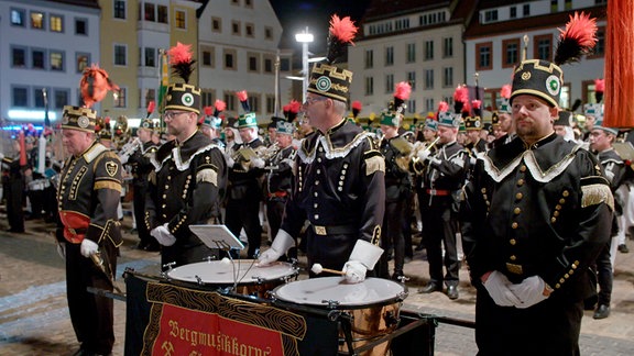 Erzgebirgische Bergmänner in Uniform mit Trommeln bei einem Zapfenstreich.