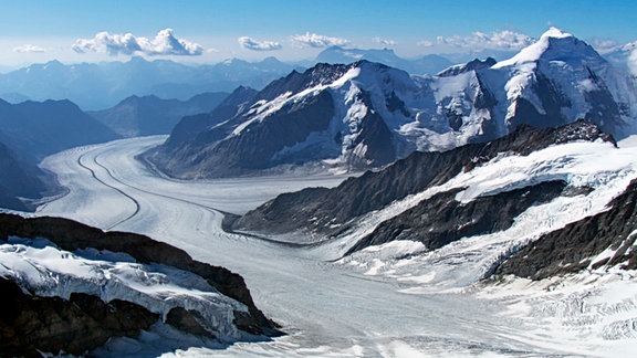 Mit gut 20 Kilometern Länge ist der Aletsch der größte Gletscher in den Alpen. Wie ein Fluss aus Eis erstreckt er sich durchs Hochgebirge. Noch wirkt er mächtig, doch sein Eisschild schmilzt Jahr für Jahr immer weiter ab.