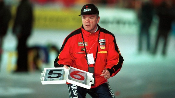 Bundestrainer Joachim Franke (Deutschland) zeigt auf einer Tafel die Rundenzeit an.