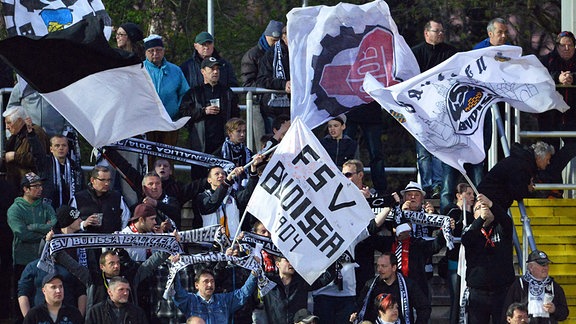 Fans von Budissa Bautzen schwenken Fahnen auf der Tribüne 