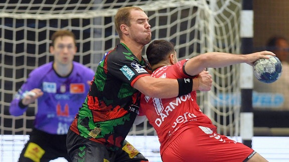 Mohamed Amine Darmoul (MT Melsungen 71) (am Ball), Tim Zechel (SC Magdeburg 9) (L) in der Abwehr