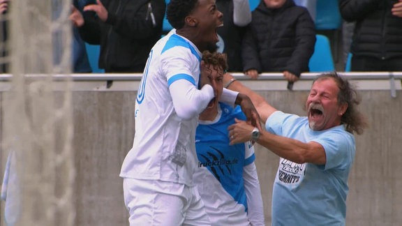 Chemnitzer Spieler und ein Fan jubeln