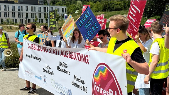 Mehrere Menschen halten ein Transparent mit der Aufschrift "Ausbildung statt Ausbeutung"