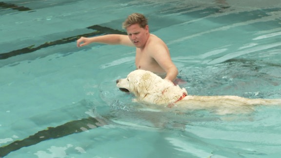 Mann und Hund im Schwimmbad