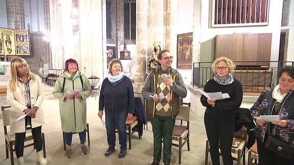 Menschen stehen in einer Kirche und singen