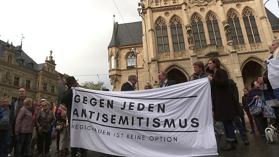 Menschen halten Transparent "Gegen jeden Antisemitismus" hoch