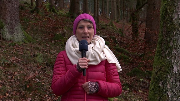 Wetterreporterin Sandra Voigtmann steht im Wald