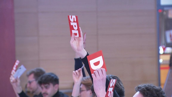 Hand hält SPD-Stimmkarte nach oben