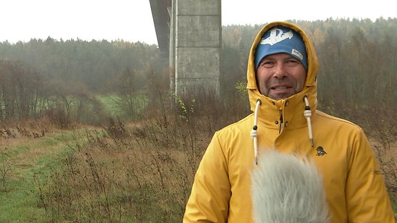 MDR Wettermoderator Jens Roder unter einer Autobahnbrücke