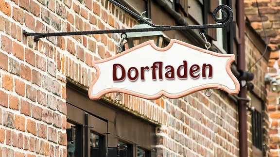 Dorfladen steht auf einem Schild, das über einer Tür hängt