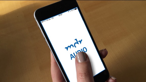 Eine Hand hält ein Iphone. darauf steht "MDR AUdio. Das inklusive Hörangebot"