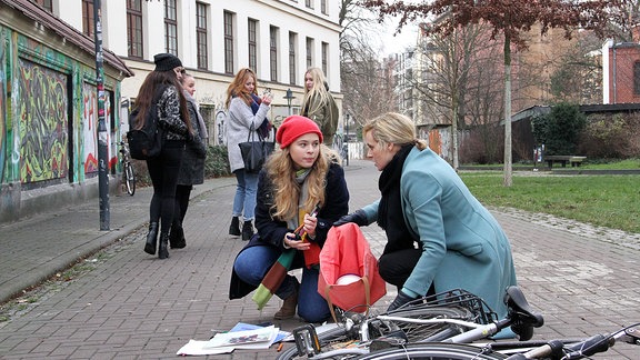 Dr. Lea Peters (Anja Nejarri, vorn, re.) hat mitbekommen, dass Lisa Schroth (Ella Zirzow, vorn, li.) in der Schule gemobbt wird. Morgens ist Lea zur richtigen Zeit an Ort und Stelle, um Lisa aus einer brenzligen Situation zu helfen. Lisa ist dankbar und offenbart Lea, dass sie dafür verantwortlich ist, dass Marlen mit einer schweren Kopfverletzung in der Sachsenklinik liegt. Marlen hat sie derart provoziert, dass Lisa sie geohrfeigt hat. Dass Marlen dadurch mit dem Kopf an einen Haken gestoßen ist, war ein Unfall.