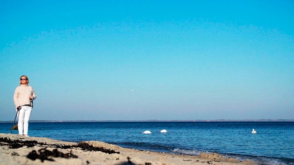 Jana (ganz links)steht am Strand - die See im Hintergrund