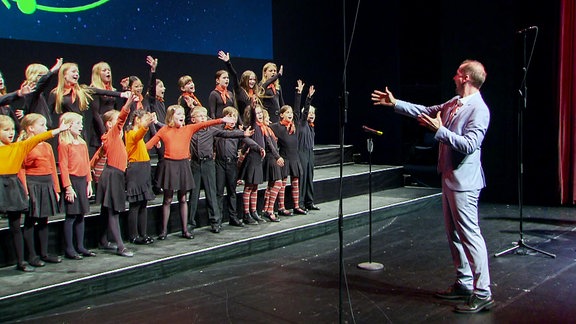 Auftritt Kinderchor mit Chormeiter (Kinder reisen die Arme hoch)