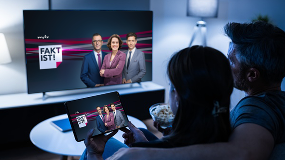 Frau und Mann schauen Fakt ist! - Sendung auf Fernseher und Tablet