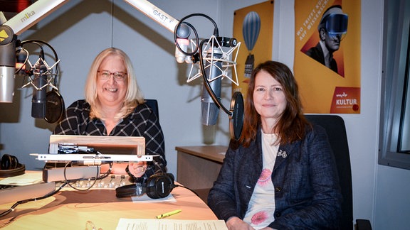 Frauen sitzen in einem Rundfunkstudio.