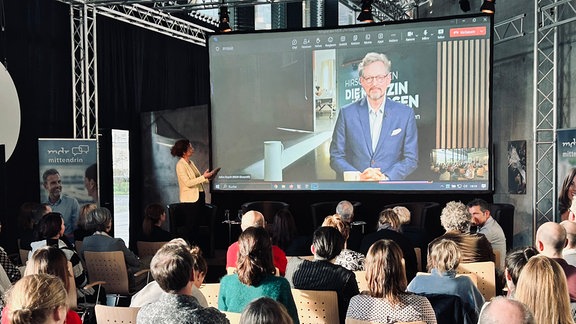 Menschen schauen auf eine Leinwand