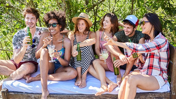 junge Menschen sitzen zusammen und trinken