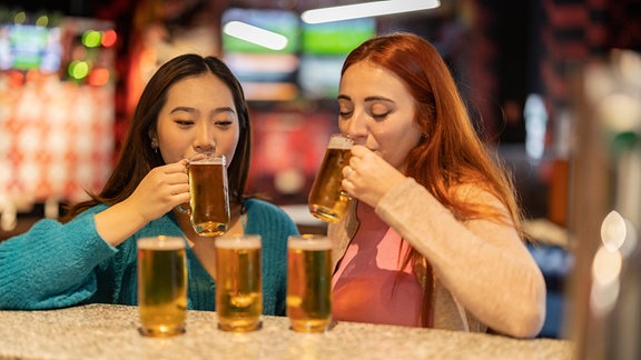 Frauen trinken aus Gläsern.