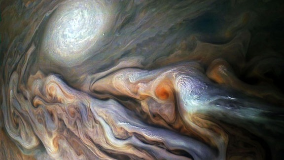 Dieses Bild der NASA-Raumsonde Juno zeigt eine Vielzahl von prächtigen, wirbelnden Wolken in Jupiters dynamischem Nördlichen Temperaturgürtel. In der Szene sind mehrere hell-weiße "Pop-up"-Wolken sowie ein antizyklonaler Sturm zu sehen, der als weißes Oval bekannt ist.