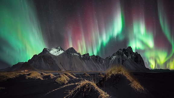 Kategorie: Polarlichter  Spektrum © Stefan Liebermann  Die Nordlichter über dem berühmten isländischen Berg Vestrahorn.  Ein Panorama aus drei Fotos, bearbeitet mit Lightroom und Photoshop.   Aufgenommen mit Sony ILCE-7SM3 Kamera, 14 mm f/1.8, 2-Sekunden-Belichtung   Standort: Vestrahorn, Island 