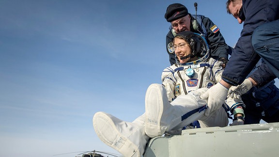 Astronautin Christina Koch ist auf der erde gelandet und steigt aus der Landekapsel.