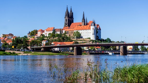 Blick auf die Altstadt von Meißen mit der Albrechtsburg im Hintergrund und der Elbe im Vordergrund.