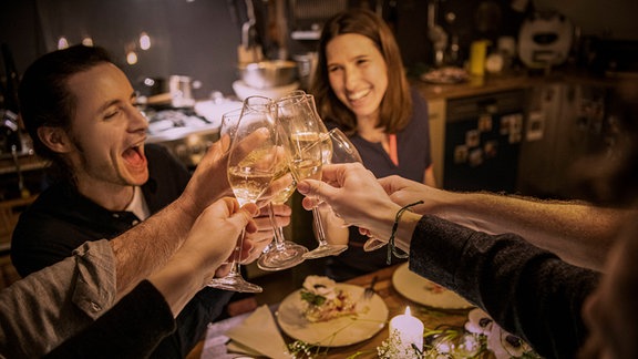 Freunde erheben Trinksprüche während der Geburtstagsfeier zu Hause