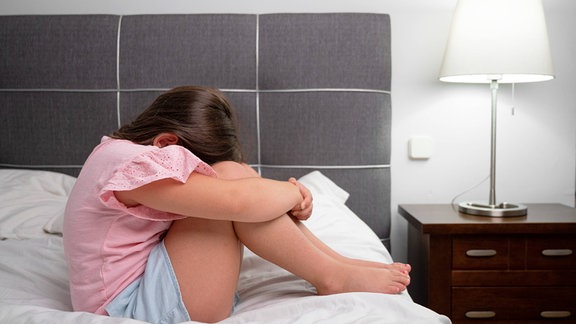 Illustration - Mädchen weint und sitzt auf dem Bett im Schlafzimmer. 