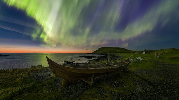 Nordlichter über Ruderboot in Wikinger-Siedlung von L'Anse aux Meadows