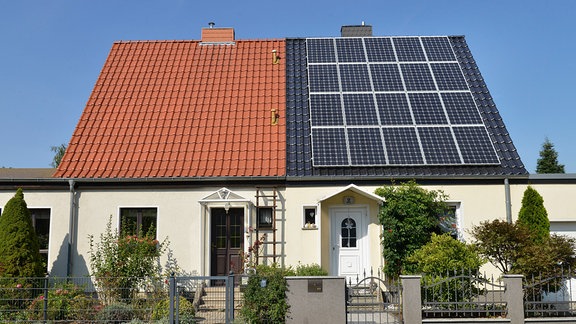 Doppelhaus - das linke Hausdach mit klassischen Schindeln, das rechte ist mit Solarmodulen bestückt. 