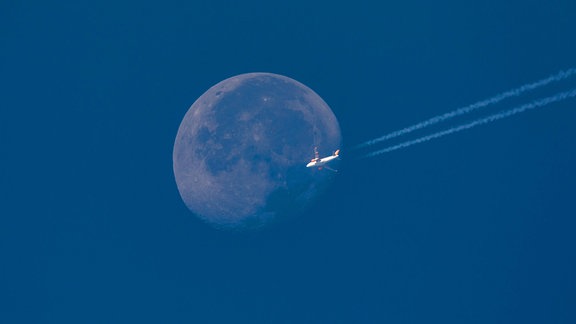 EasyJet Airbus fliegt mit Kondensstreifen vor Vollmond